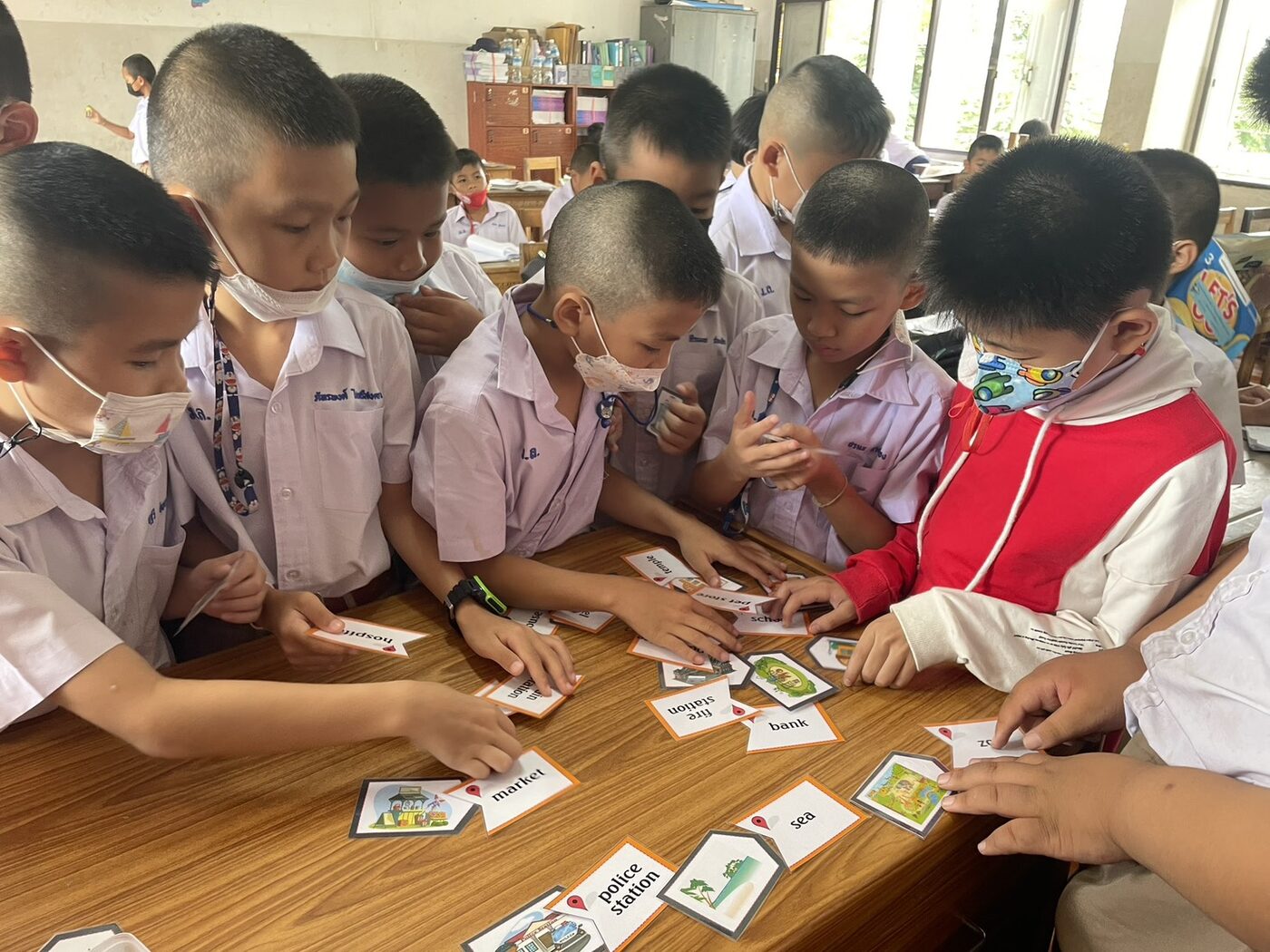 นักเรียนชั้น ป.3 จับคู่บัตรภาพกับบัตรคำหมวดสถานที่ market police station bank fire station sea
